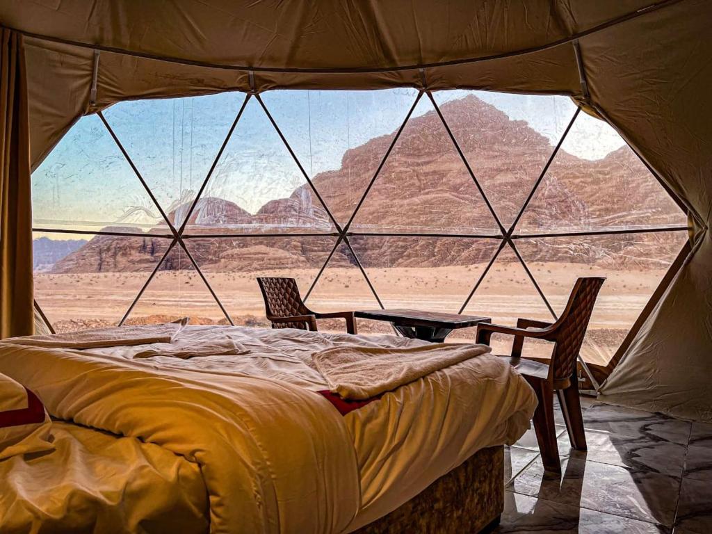 DisahLuxury tent camp的帐篷内的一张床位,享有沙漠美景