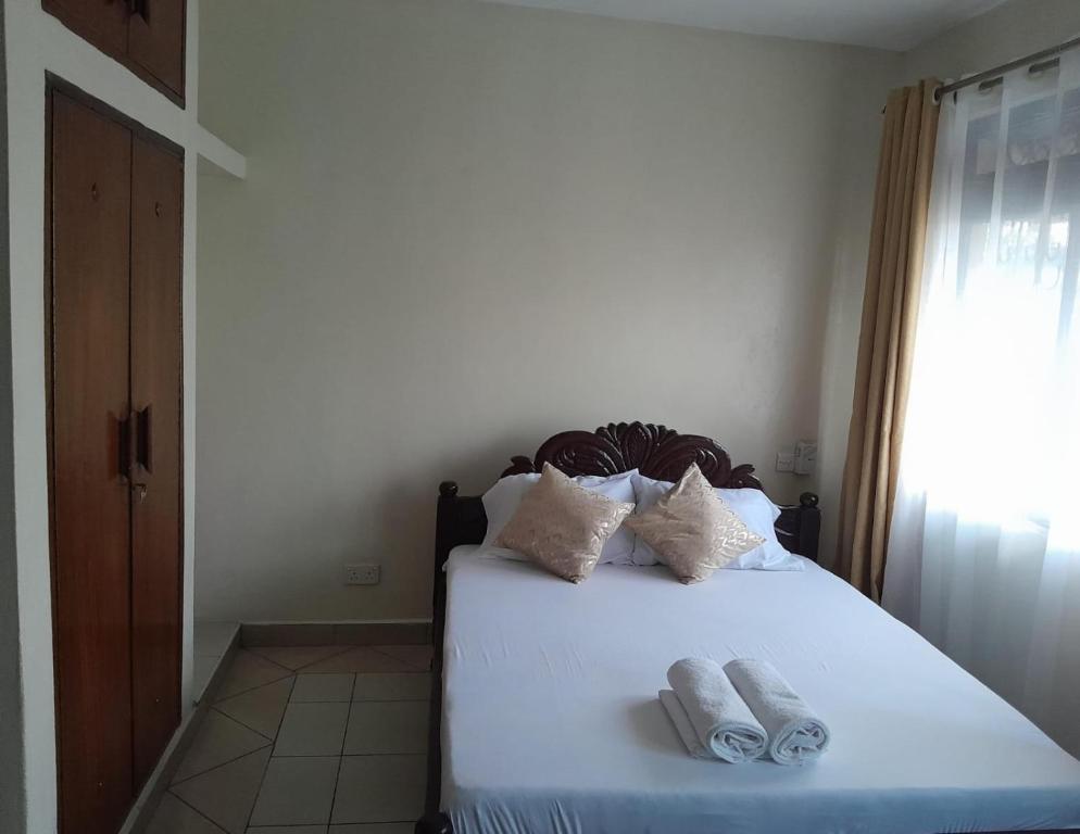 蒙巴萨Galene Abode Studio Apartment, Nyali的一间卧室配有一张床,上面有两条毛巾