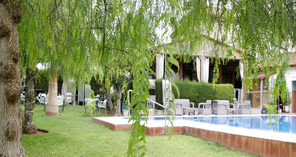 La GuijarrosaHostal Al-Andalus的一个带游泳池、椅子和树木的度假酒店