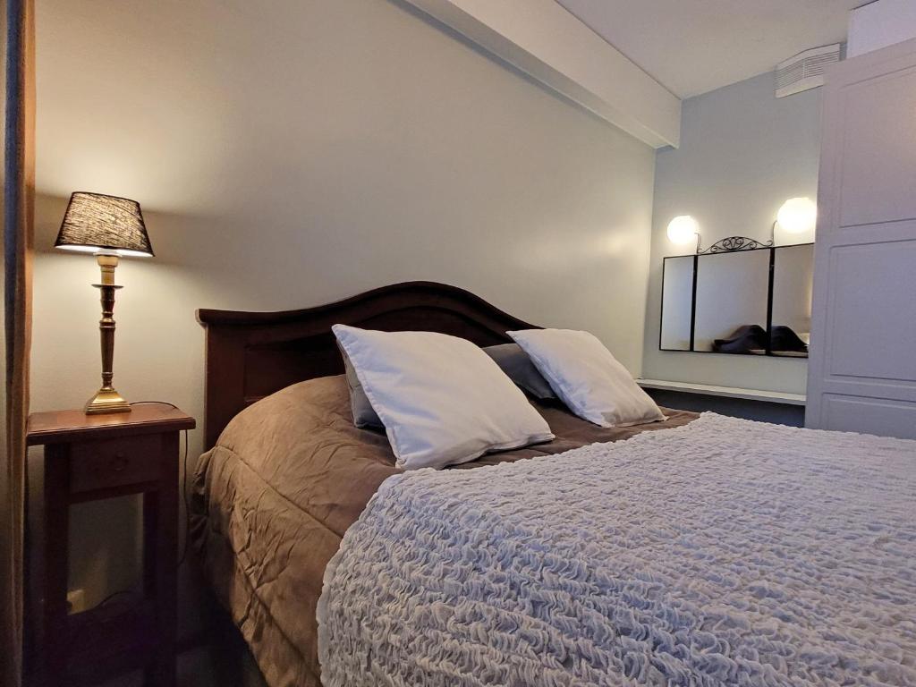 塔库沃里Apartments Golf的一间卧室配有带两个枕头和一盏灯的床