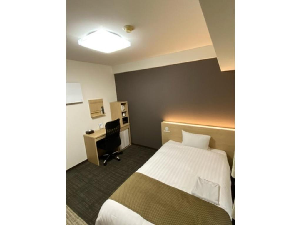 KanonjiHotel Sunny Inn - Vacation STAY 20411v的配有一张床和一张书桌的酒店客房