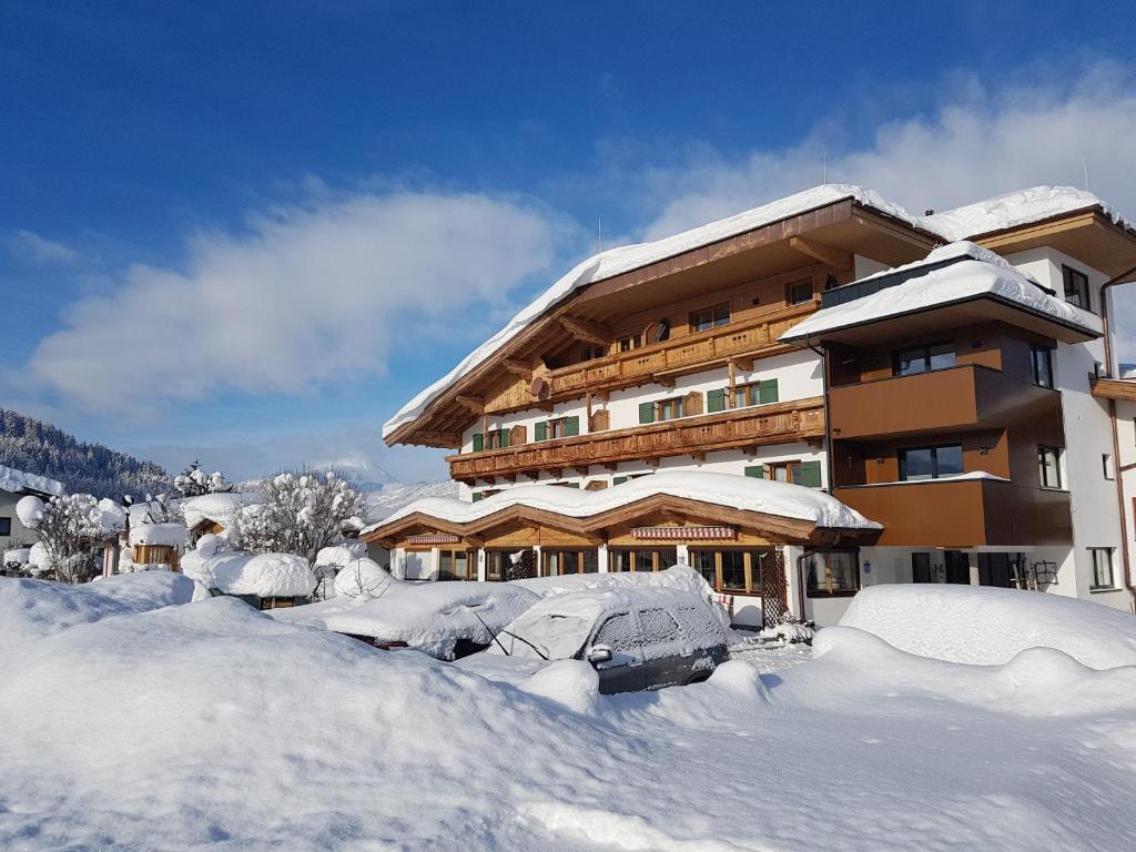 蒂罗尔-基希贝格福鲁克斯图克塔嫩霍夫酒店的一座积雪覆盖的建筑,周围积雪很多