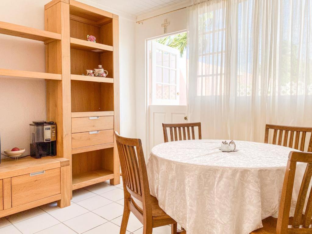 奥拉涅斯塔德Tropical Retreat Stay Aruba的一间带桌椅和窗户的用餐室