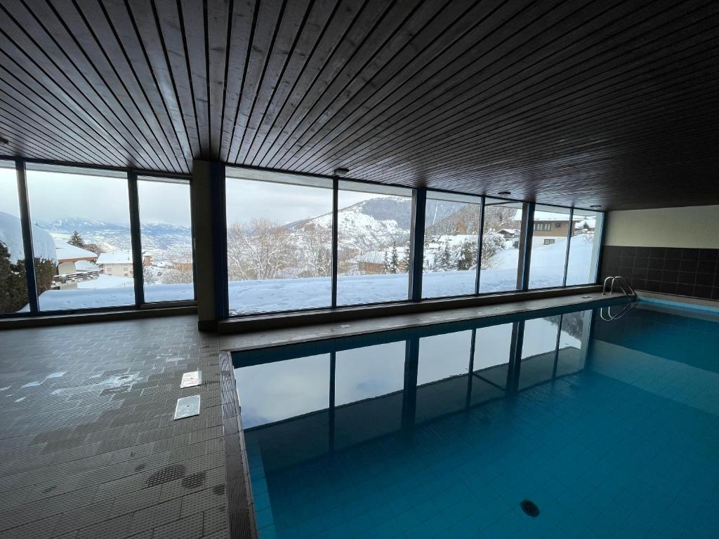 南达2,5 pièces à Haute-Nendaz, grande terrasse, piscine, sauna, tennis的享有白雪 ⁇ 山景的游泳池