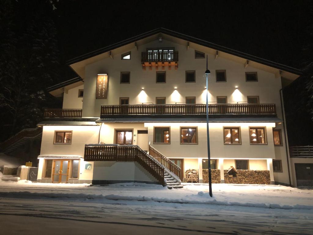 阿贝托内派尼尔利一号酒店的一座白色的大建筑,在晚上下雪