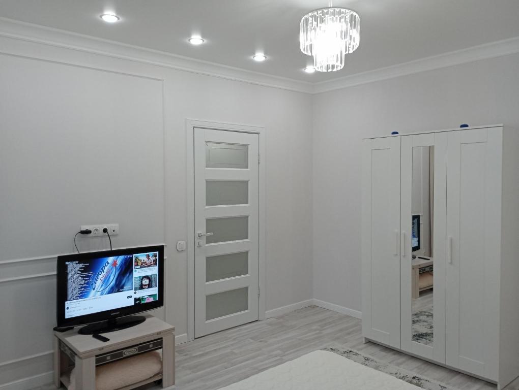 阿斯塔纳1-но комнатная квартира в центре Астаны ЖК Sezim Qala 4的一间白色的房间,桌子上放有电视