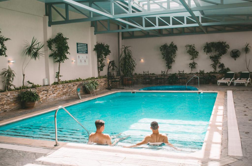 萨尔塔卡萨利尔酒店的两个男人坐在游泳池里