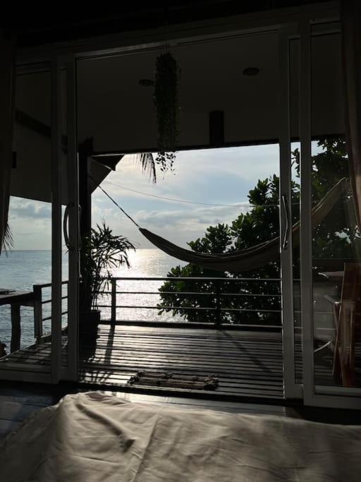 帕干岛Sea Lulaby的卧室设有吊床,享有海景。