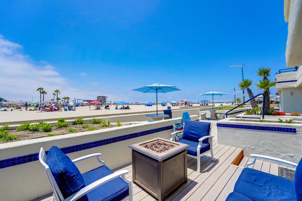 圣地亚哥Oceanfront Condo with Front Patio, Gas Grill, Fire Pit - Prime Location!!的露台设有桌椅,享有海滩美景