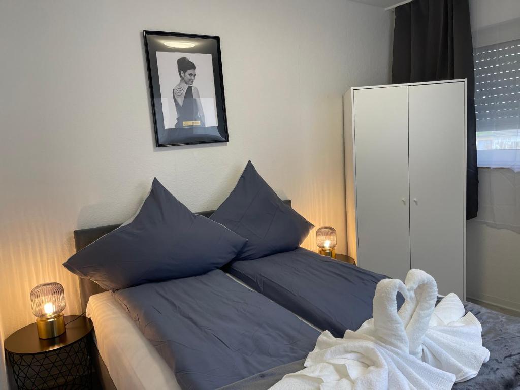 波恩City Apartment am Rhein Bonn的一间卧室配有一张带蓝色枕头的床