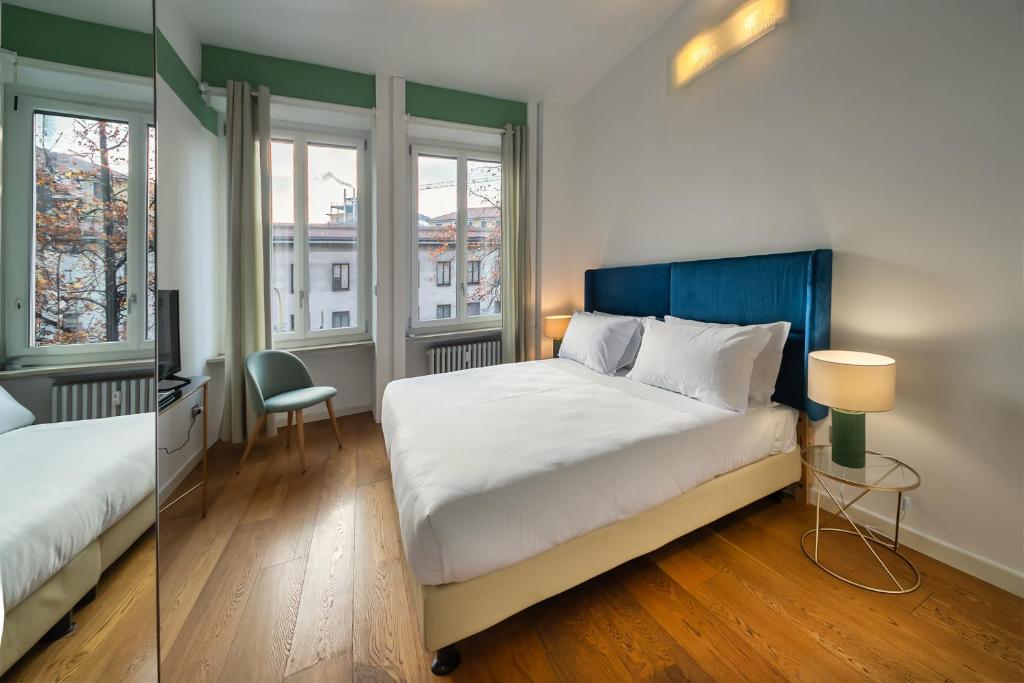 米兰Santa Sofia Home的一间卧室配有一张床、一张书桌和两个窗户。