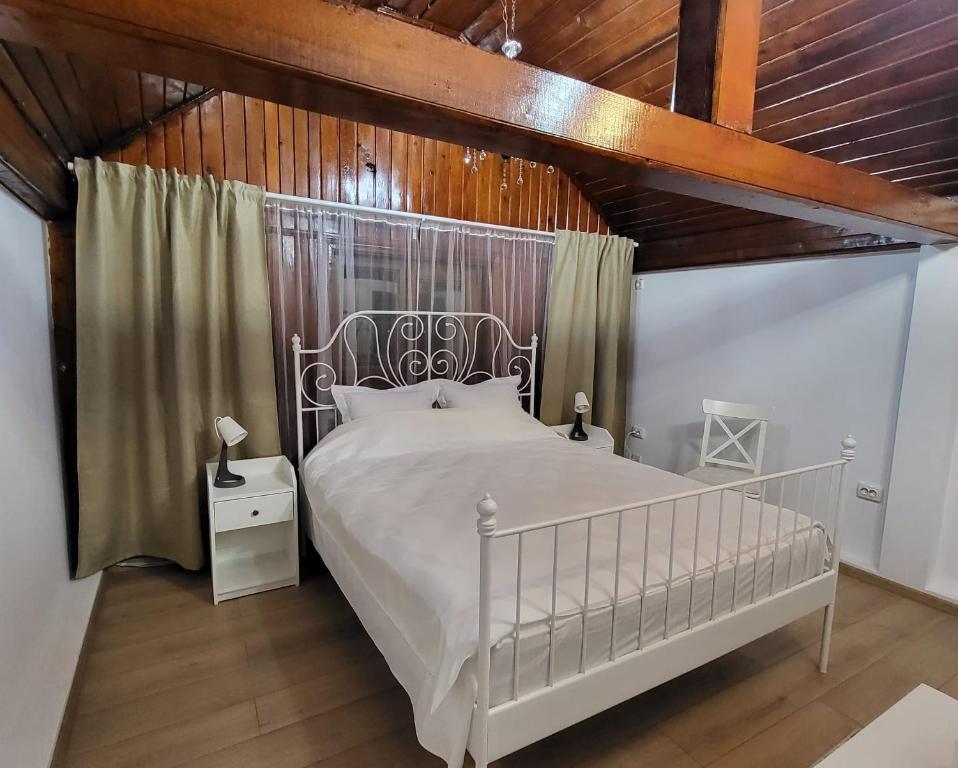 布加勒斯特Adac Boutique Hotel的卧室设有白色的床和木制天花板。