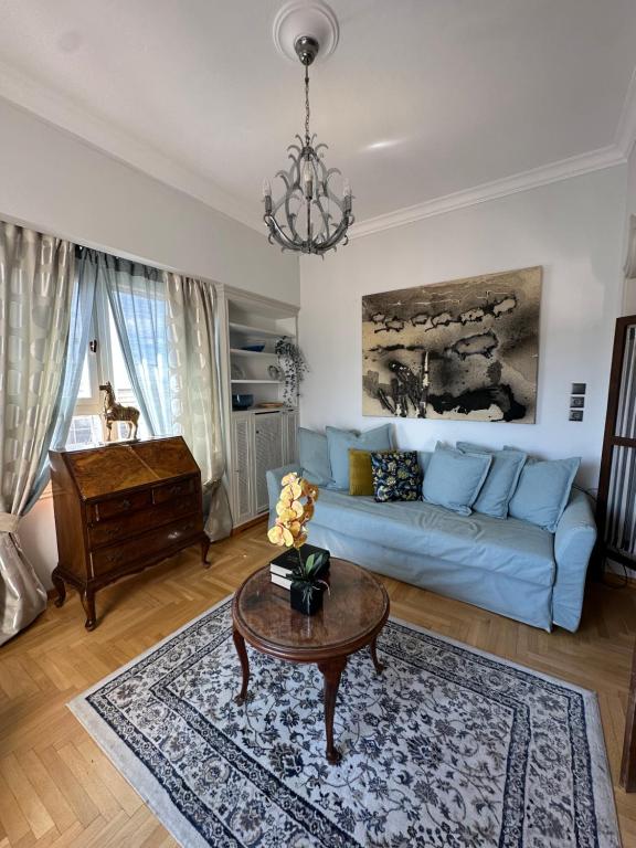 雅典2 BD Apt in Syntagma with Acropolis view的客厅配有蓝色的沙发和桌子