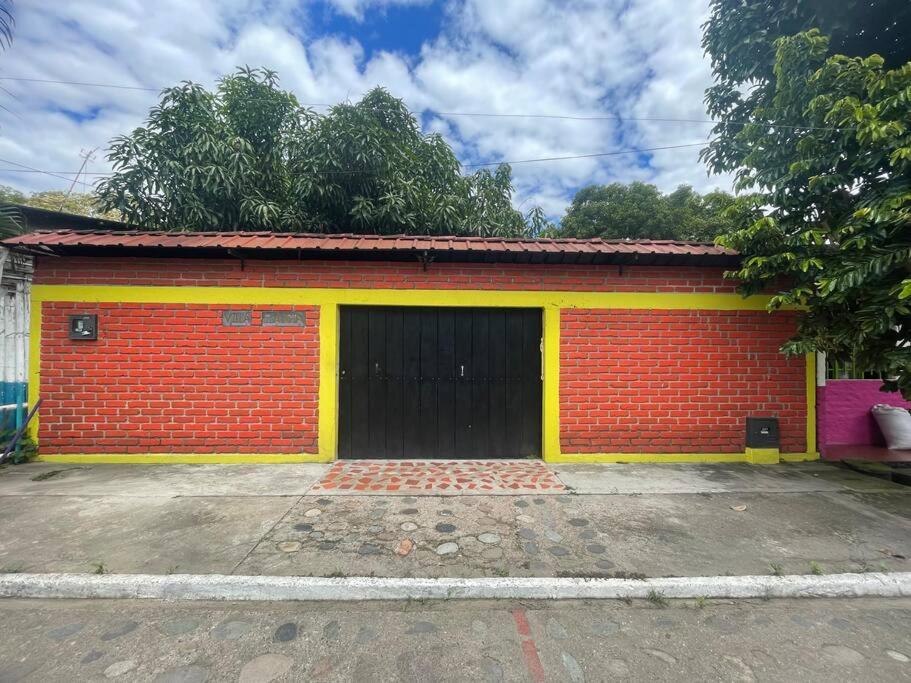 GarzónLa Casa de Mónyk de la P En la jagua Huila的一座红色和黄色的建筑,设有车库