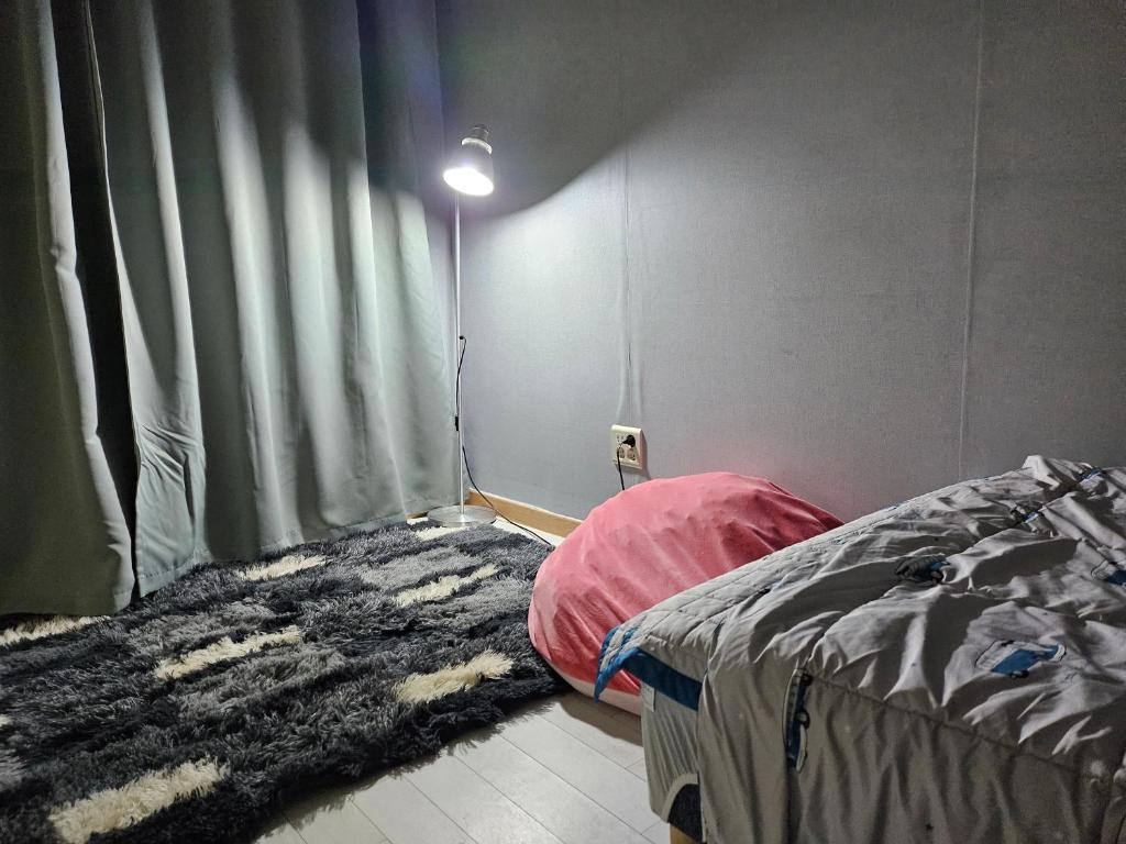 首尔Urban Space Sinnonhyeon的卧室配有一张床,墙上有灯