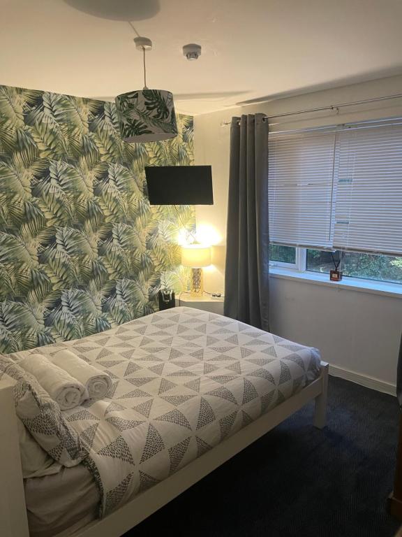 HenwickThe Swan Inn的一间卧室配有一张床,墙上贴有 ⁇ 萝壁纸