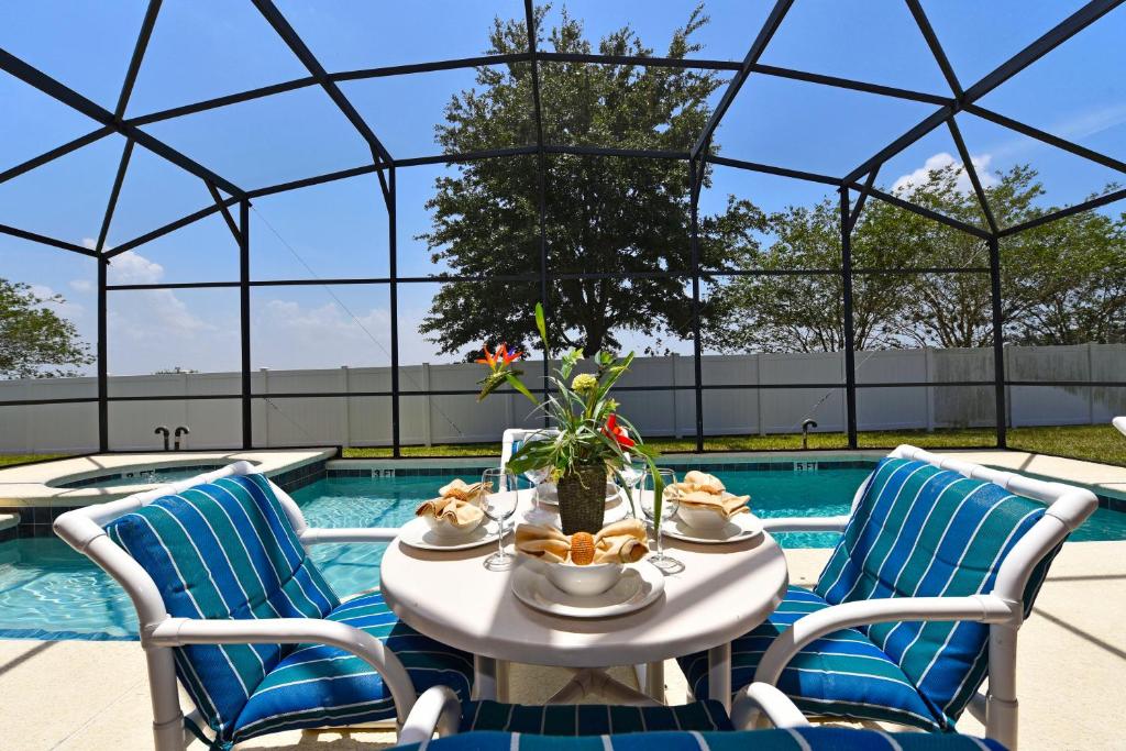 达文波特Family Friendly Home, South-facing Pool,Spa, Gated Resort near Disney -928的一张桌子,上面放着一碗食物,放在游泳池边