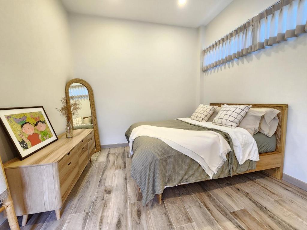 合艾Self house (Cozy private house)的一间卧室配有一张床,铺有木地板