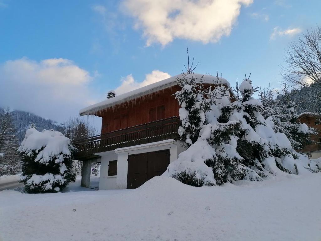 拉克吕萨Chalet La Clusaz, 5 pièces, 6 personnes - FR-1-459-129的一座房子,前面有树木,被雪覆盖着