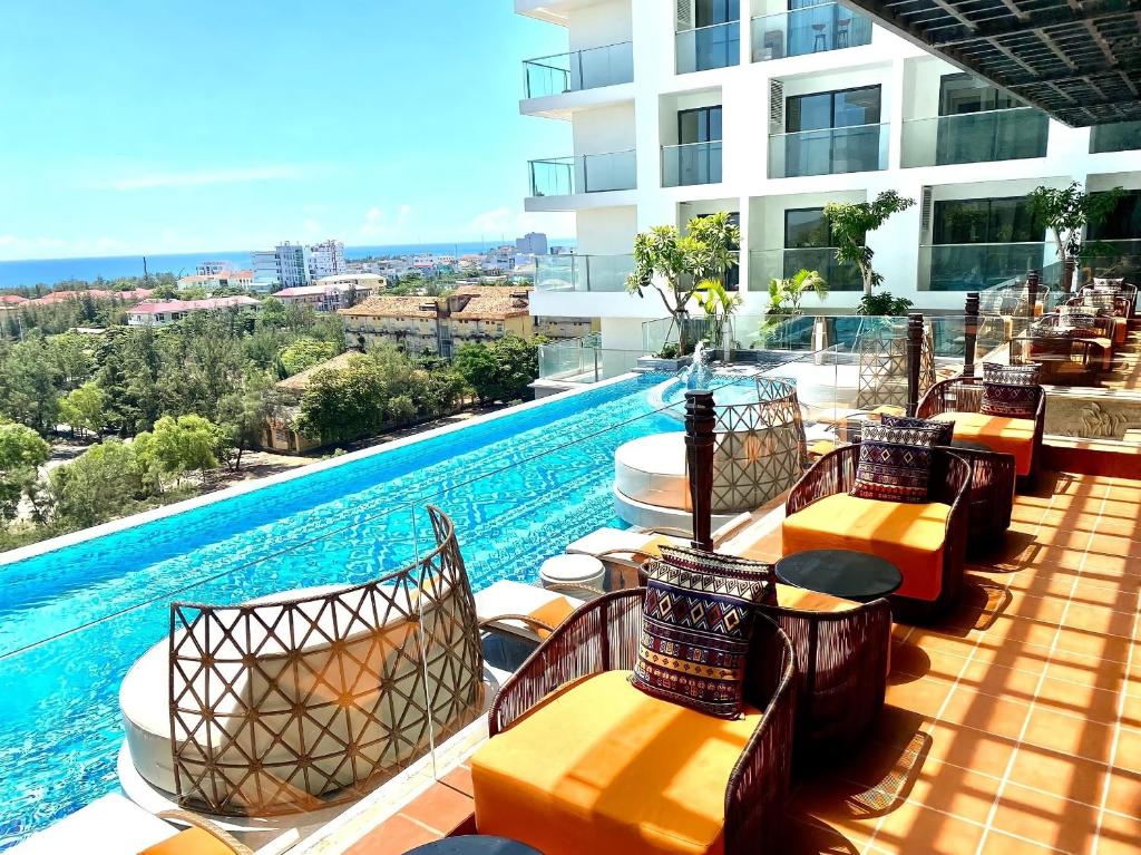 绥和市Mia Apec Mandala Phú Yên的酒店庭院设有椅子和游泳池