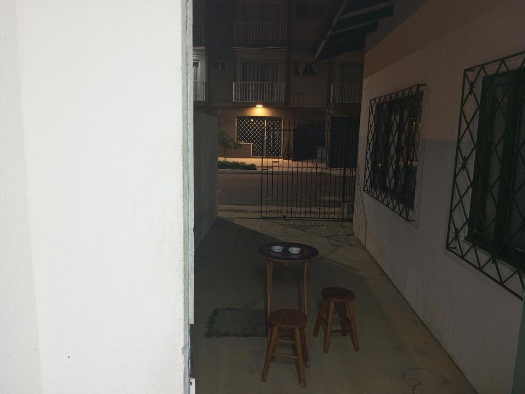 巴拉奈里奥-坎布里乌B & B Hostels Balneário的走廊上设有两个凳子和一张桌子