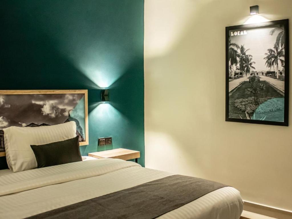 卡拉奇LOKAL Rooms x Shahrah-e-Faisal (Nursery)的一间卧室设有一张床和绿色的墙壁
