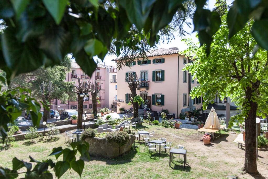 阿巴迪亚圣萨尔瓦托雷法布里尼酒店的一座公园,公园里设有桌椅和建筑