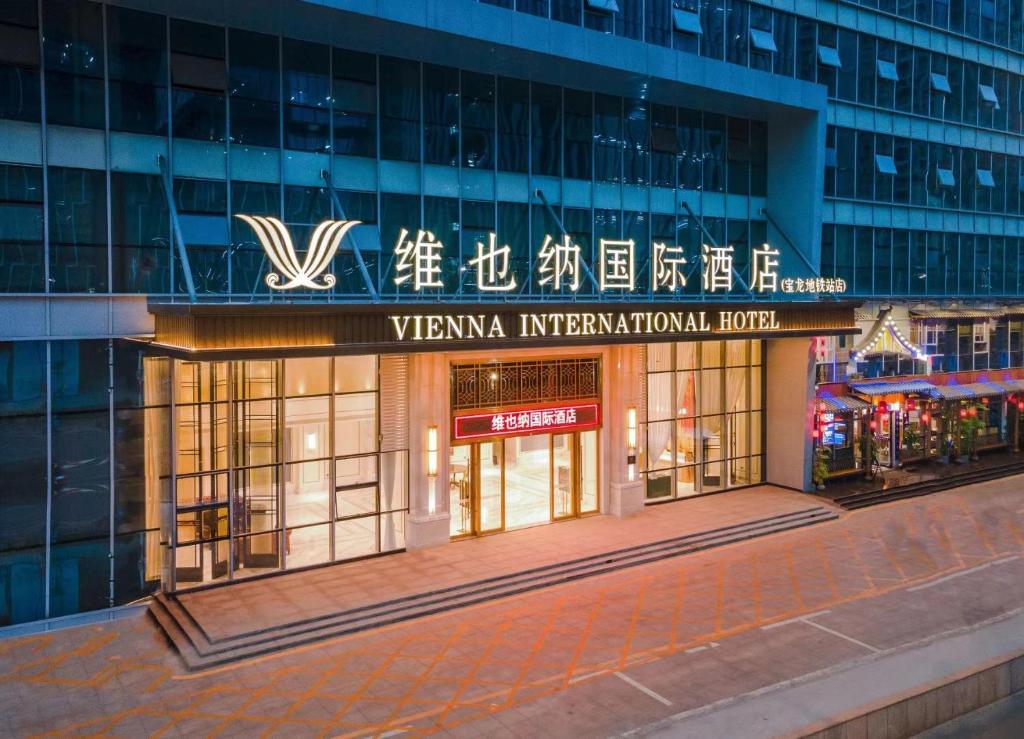 龙岗Vienna International Hotel Shenzhen Baolong subway Station branch的一座带有读取vynna国际酒店标志的建筑