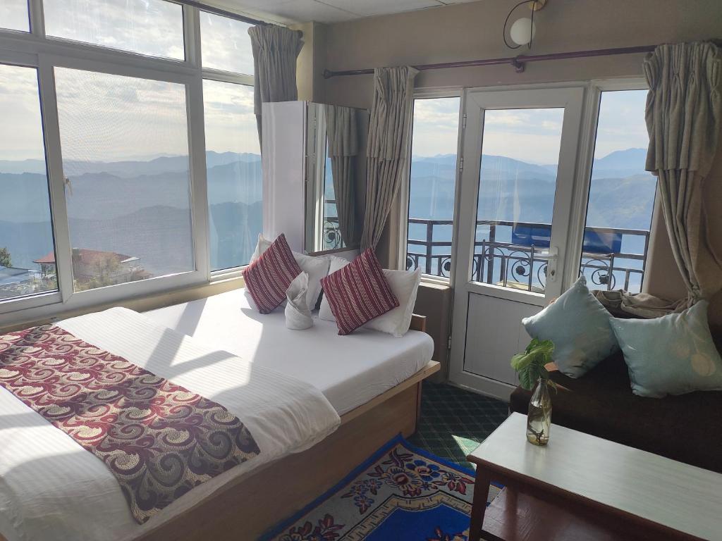 博卡拉Hotel High Ground Inn Sarangkot的酒店客房设有一张床和一个大窗户
