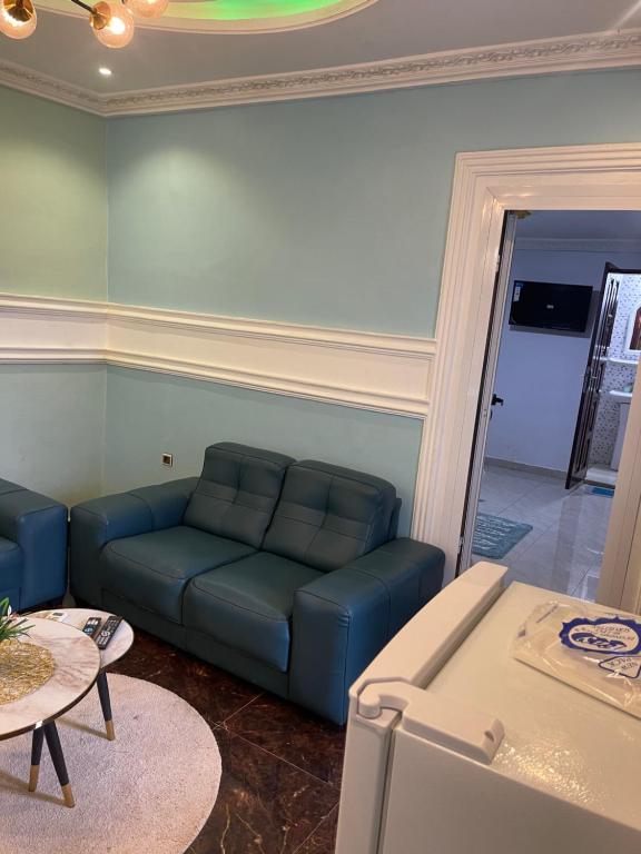 林贝Primier Mansion Guest Home的客厅配有蓝色的沙发和桌子