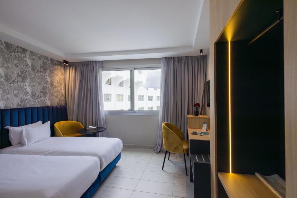 丹吉尔肯兹索拉祖尔酒店的配有一张床、一张书桌和一扇窗户的酒店客房