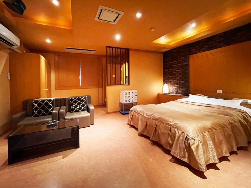 YobitoHotel ARUN的一间大卧室,配有一张床和一张沙发