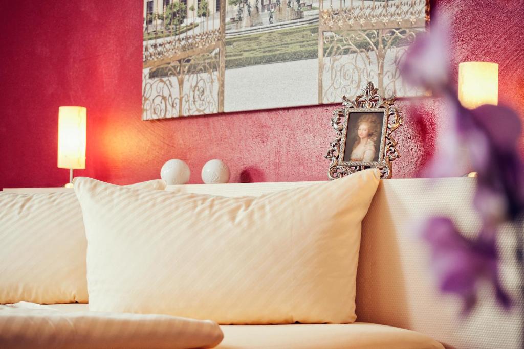 米罗Alte Schlossbrauerei的卧室配有白色床和粉红色墙壁