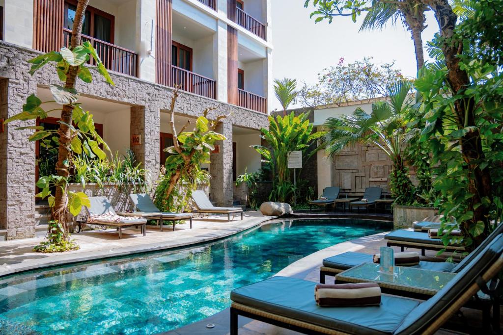 沙努尔阿卡纳精品酒店的一个带躺椅的酒店游泳池