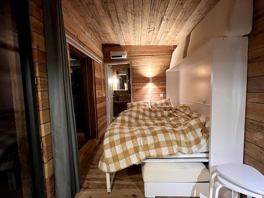 Lissac et MouretLes cabanes de Julie的一间卧室配有一张带 ⁇ 子毯子的床