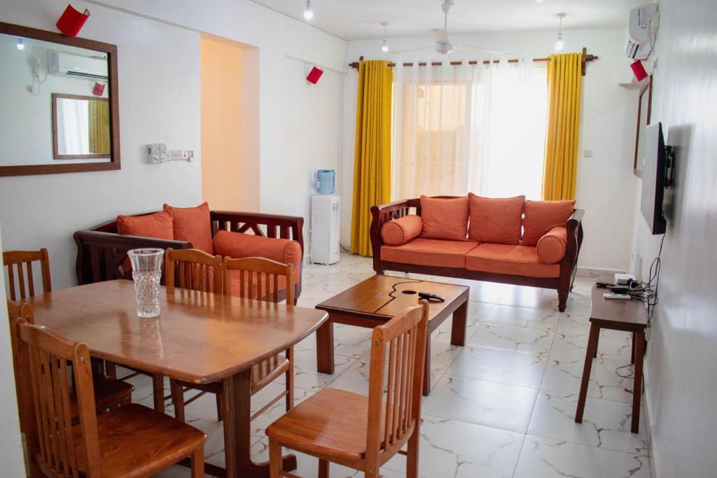 蒙巴萨H20 APARTMENTS NYALI的客厅配有桌子和沙发