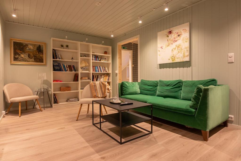 特罗姆瑟Urban and stylish apartment in city centre的客厅配有绿色沙发和桌子