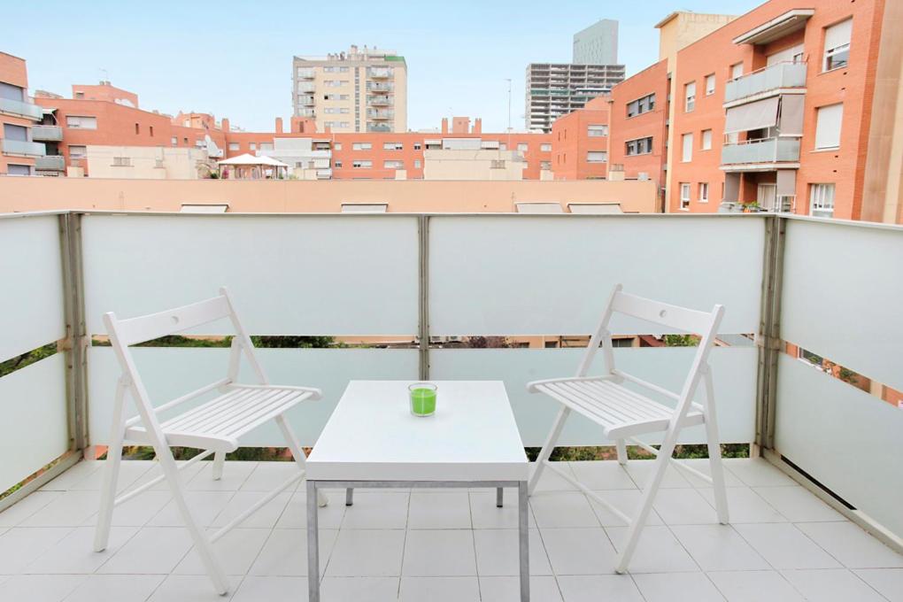 巴塞罗那1223 - POBLENOU APARTMENT的美景阳台配有两把椅子和一张桌子