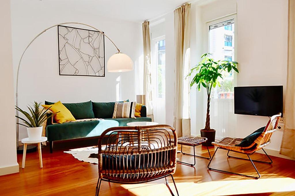 瓦伦西亚Hola Valencia - Holiday Apartments的客厅配有绿色沙发和椅子