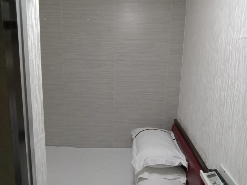 香港金源賓館 Golden Yuan Guest House的小房间设有一张带两个枕头的床