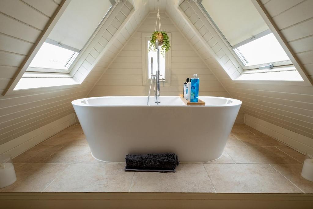 贝里圣埃德蒙兹Charming 2 bedroom property的阁楼浴室设有白色浴缸,配有天窗。