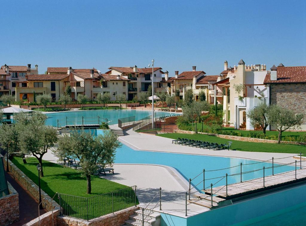 佩斯基耶拉德加达Lugana Resort & Sporting Club - Sermana Village的一座带游泳池和部分建筑的度假村