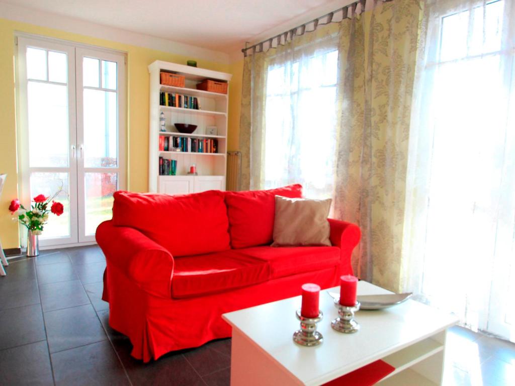 奥斯特巴德里克Villa Antonia Whg_ 03的客厅设有红色沙发,配有窗户
