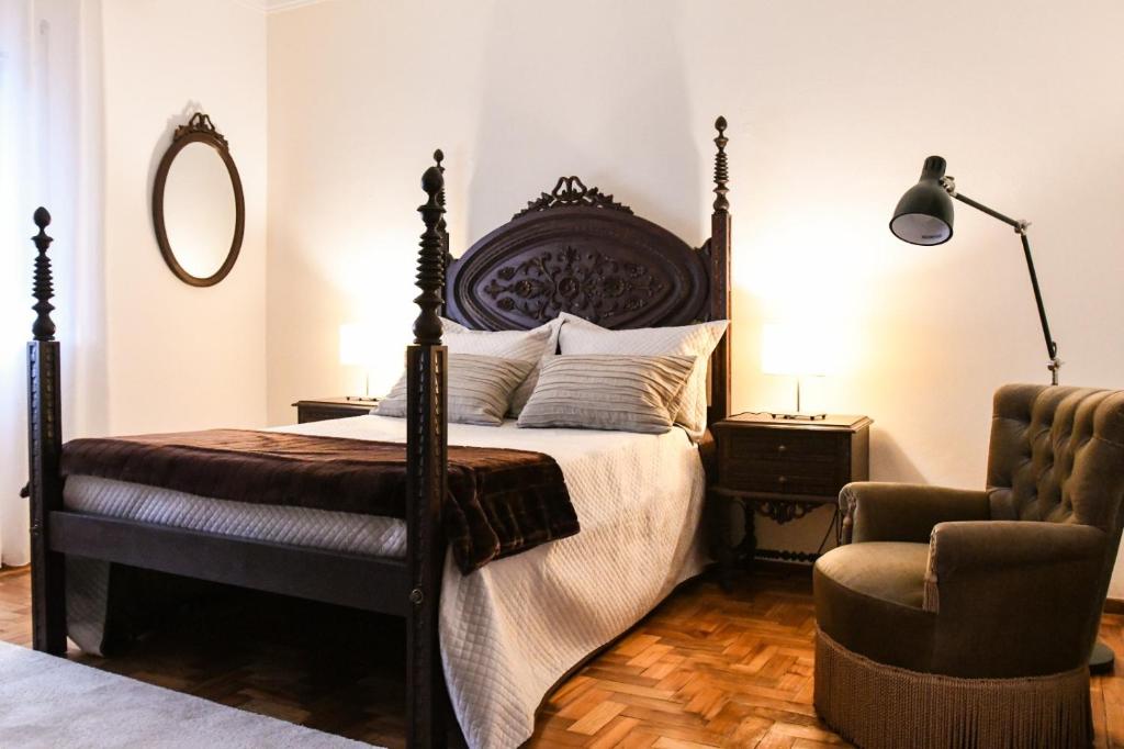 科尔武河畔米兰达Casa Raposo的一间卧室配有一张大床和一把椅子