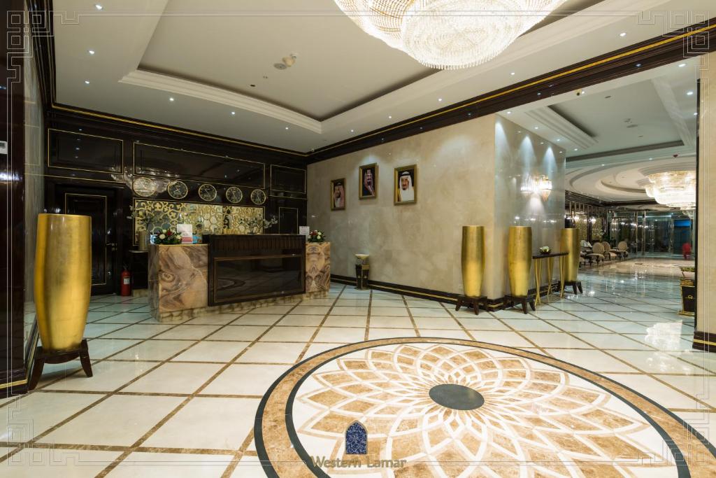 吉达西拉马尔酒店的酒店大堂,设有桌子和柜台