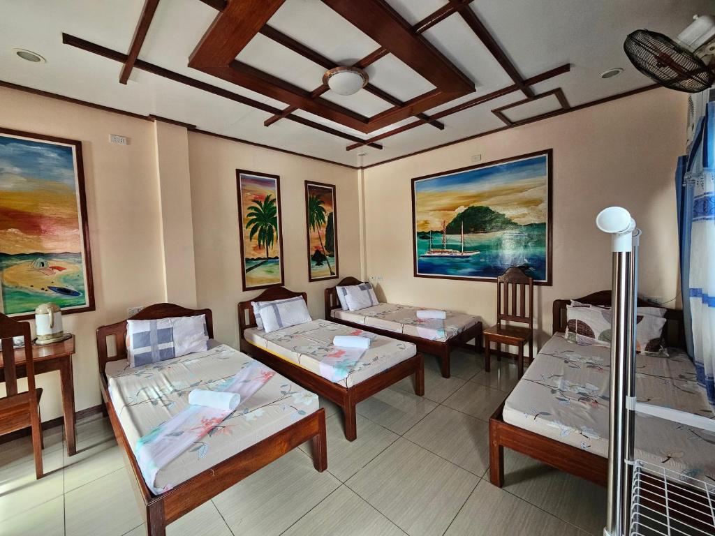 圣维森特费兰科旅者宾馆的客房设有三张床,墙上挂有绘画作品