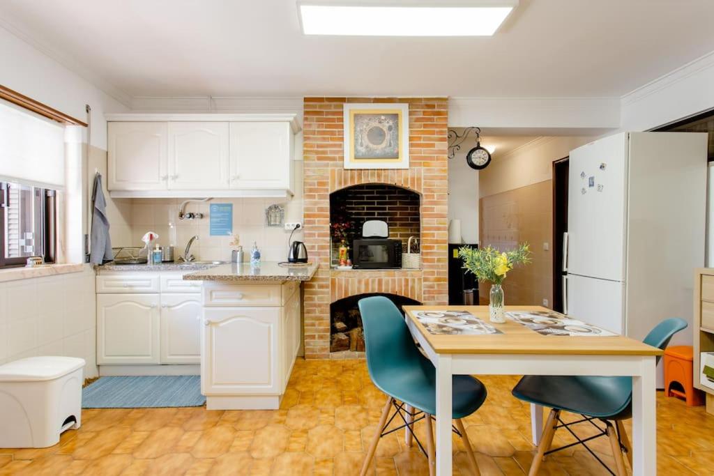 卡尔卡维洛斯Paradise Suites的厨房配有桌子和砖砌壁炉