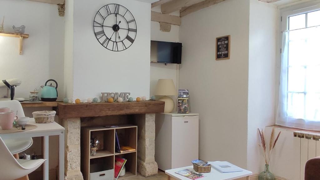 布鲁瓦Blois City - Le Petit Saint Jean的一间带壁炉的厨房,墙上挂着一个钟