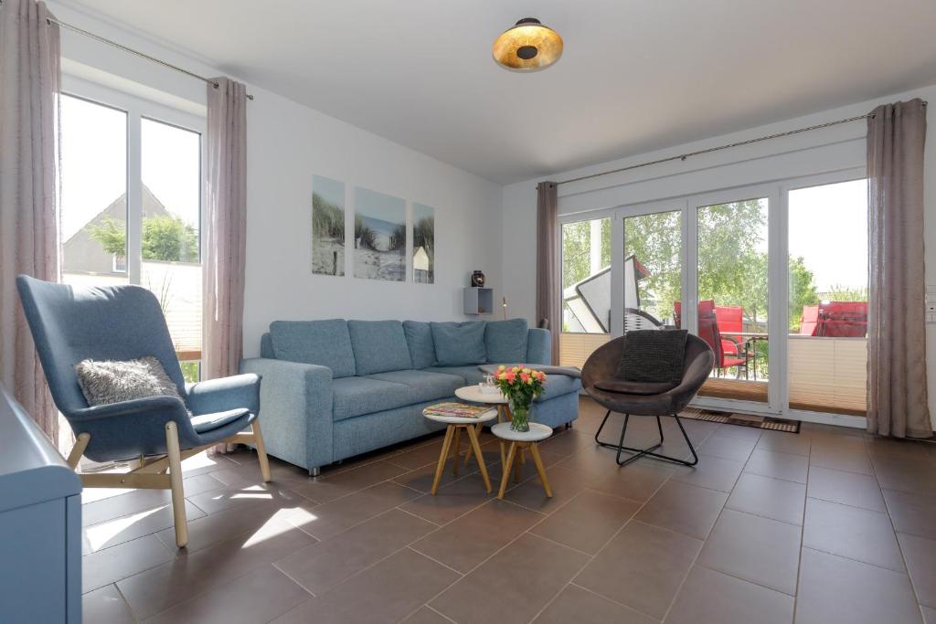 奥斯特巴德里克Haus Emilia Whg Baltic Dreams的客厅配有蓝色的沙发和椅子