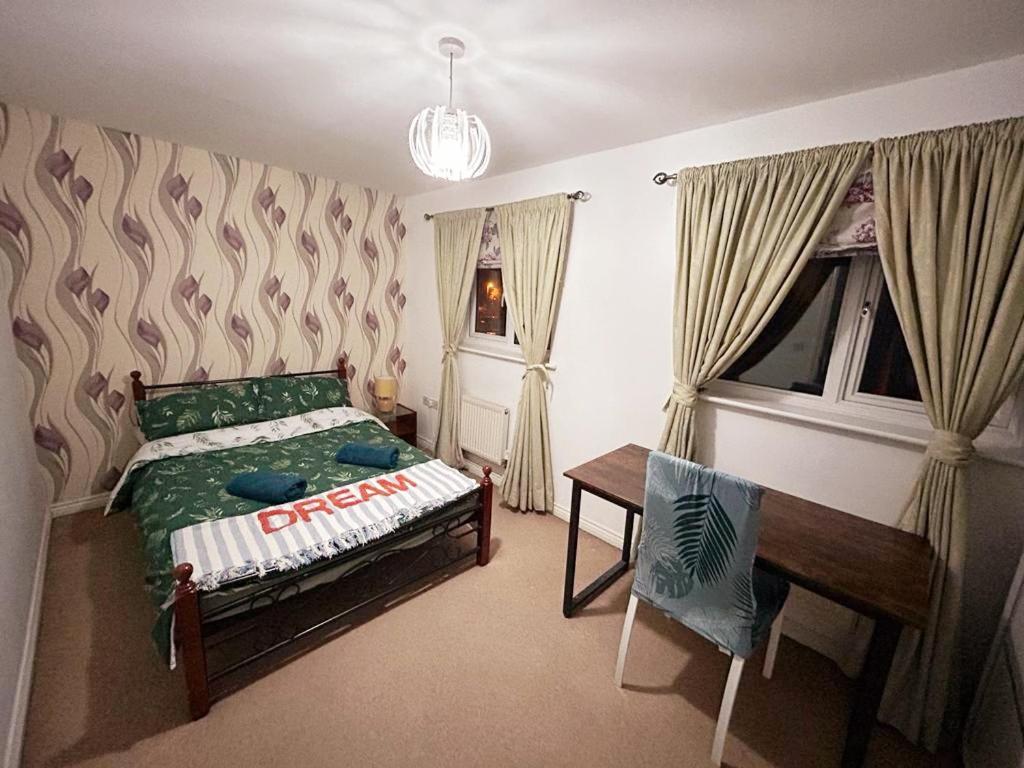 曼彻斯特Queens Rooms, a Perfect Stay, Next to Shopping Parks and Central Manchester的一间卧室配有一张床、一张书桌和一个窗户。